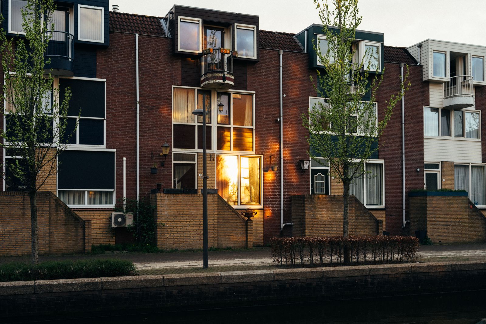 A row of modern brick townhouses with large windows at sunset.