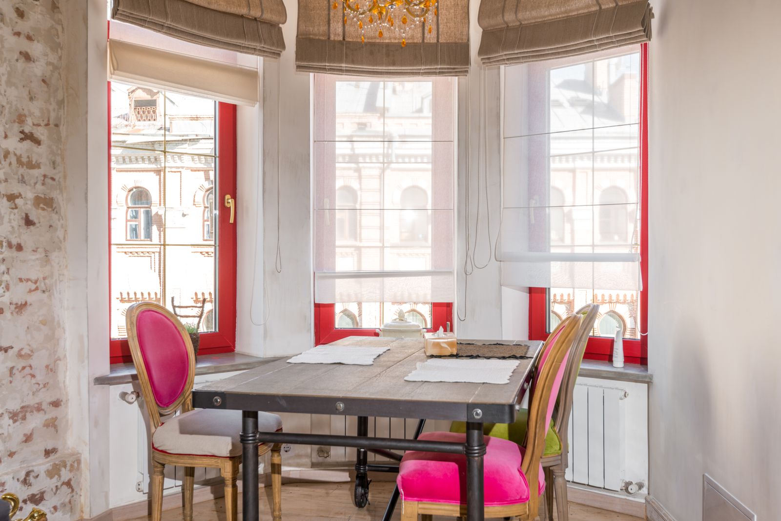 A bright dining room with tall painted window frames.